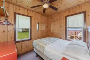a bedroom with a bed and two windows at TB6 Thunder Bay Resort Cabin 6 in Phelps