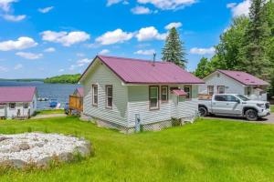 a house with a truck parked in front of it at TB6 Thunder Bay Resort Cabin 6 in Phelps