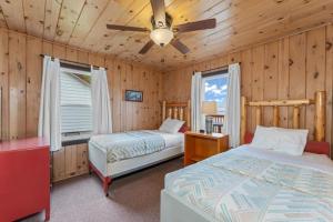 a bedroom with two beds and a ceiling fan at TB3 Thunder Bay Resort Cabin 3 in Phelps