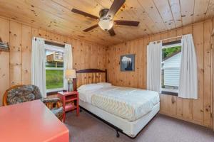 a bedroom with a bed and a ceiling fan at TB3 Thunder Bay Resort Cabin 3 in Phelps +7 photos