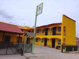a yellow building with a sign in front of it at Hotel Ecológico Temazcal in Creel