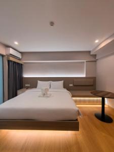 a bedroom with a large white bed and a table at Lucky Elephant Hotel in Ban Bang Toei (1) +8 photos