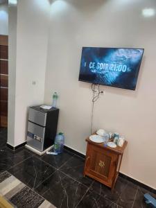 a room with a television on the wall and a table at Gassama studio in Dakar