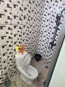 a bathroom with a white toilet and a black and white wall at Gassama studio in Dakar