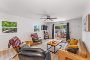 a living room with couches and chairs and a ceiling fan at TB-13 Thunder Bay Resort Cabin 13 in Phelps