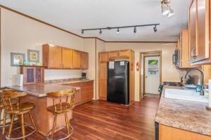 a kitchen with a black refrigerator and wooden cabinets at TB-15 Thunder Bay Resort Cabin15 in Phelps