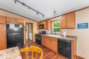 a kitchen with wooden cabinets and a black refrigerator at TB-15 Thunder Bay Resort Cabin15 in Phelps