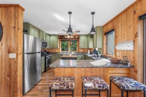 a kitchen with green cabinets and a stainless steel refrigerator at Clover Pines in Eagle River