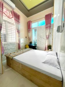 a bedroom with a large bed with red curtains at Khách Sạn LaMere Bến Tre in Ben Tre