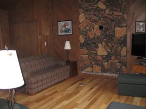 a living room with a couch and a stone wall at Bayview Resort Sunset Lookout Cabin 6 in Saint Germain