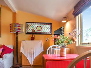 a living room with a table and a window at Owls Nest in Stradbroke