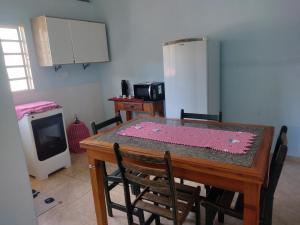 a kitchen with a table with chairs and a refrigerator at chalé 8a 4 in Cunha
