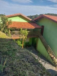 a green house with a staircase next to it at chalé 8a 4 in Cunha