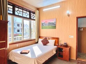 a small bedroom with a bed with a window at Palm Lodge in Bố Trạch +53 photos
