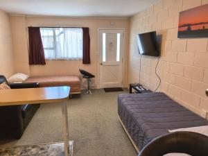 a hotel room with a bed and a tv at Judges Pool Motel Turangi in Turangi