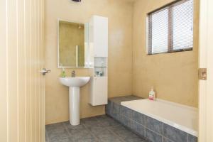 a bathroom with a sink and a bath tub at Arrowtown Dress Circle in Arrowtown +10 photos