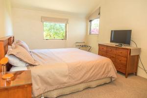 a bedroom with a bed and a television on a dresser at Arrowtown Dress Circle in Arrowtown