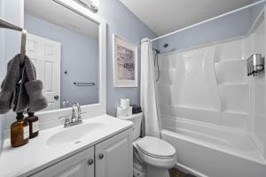 a white bathroom with a sink and a toilet at New Spacious Renovated Townhouse in Spring Hill +15 photos