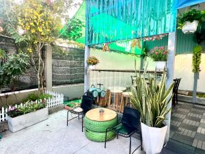 a patio with a table and chairs and plants at Khách Sạn LaMere Bến Tre in Ben Tre
