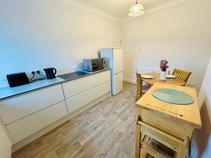 a small kitchen with a table and a refrigerator at Rural boutique private flat in Bedford