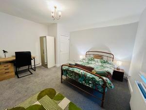 a bedroom with a bed and a desk and a chair at Rural boutique private flat in Bedford
