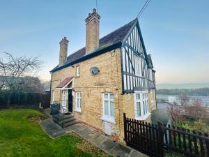 an old brick building with two chimneys on top at Rural boutique private flat in Bedford