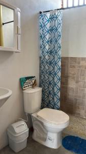a bathroom with a toilet and a shower curtain at Mi refugio in Moñitos +8 photos
