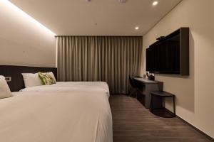 a hotel room with two beds and a desk at Kolon Hotel in Gyeongju
