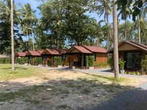 a row of resorts with palm trees in the background at Walden Moon Resort in Ko Lanta Yai