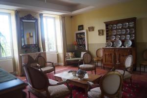 sala de estar con sillas, mesa y chimenea en Le Domaine de Rochefort, en Dissangis