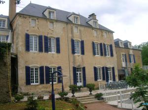 un gran edificio con persianas azules en Le Domaine de Rochefort, en Dissangis