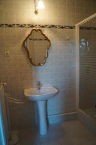 baño con lavabo y espejo en la pared en Le Domaine de Rochefort, en Dissangis