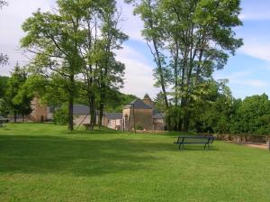 un parque con un banco en el césped en Le Domaine de Rochefort, en Dissangis