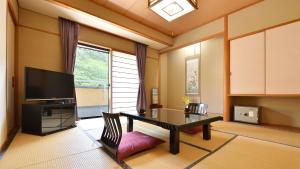 a living room with a table and a television at Bouzantei Kotobuki in Ueda +51 photos