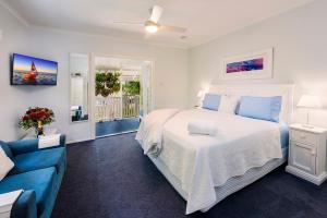 a bedroom with a bed and a blue couch at Debbie's Place in Rainbow Beach
