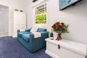 a living room with a blue couch and a tv at Debbie's Place in Rainbow Beach