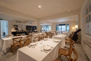 a dining room with white tables and chairs at Mocun Resort in Deqing