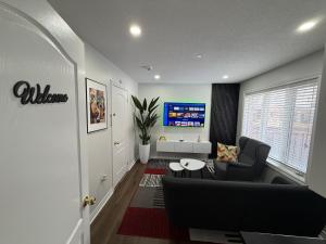 a living room with a couch and a tv at Cozy Private Two-Level Suite In Brampton With Separate Entrance And Living Area on Main Floor in Brampton +14 photos