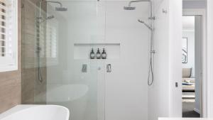 a bathroom with a glass shower with a toilet at Serenity in Corlette +20 photos