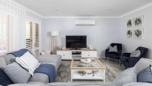 a living room with a couch and a tv at Serenity in Corlette