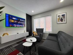 a living room with a couch and a tv at Cozy Private Two-Level Suite In Brampton With Separate Entrance And Living Area on Main Floor in Brampton