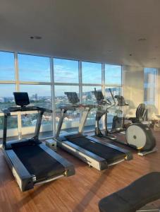 a gym with cardio machines and a large window at Cozy Loft Studio with Balcony in Cebu City in Cebu City