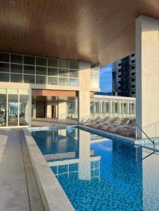 a large building with a swimming pool in front of it at Cozy Loft Studio with Balcony in Cebu City in Cebu City