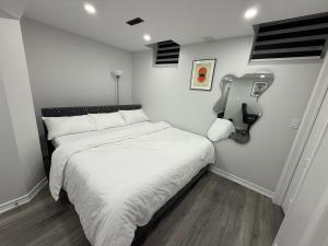 a small bedroom with a bed with white sheets at Cozy Private Two-Level Suite In Brampton With Separate Entrance And Living Area on Main Floor in Brampton