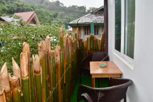 a wooden fence with chairs and a table on a balcony at Apartment El Nido in El Nido