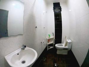 a white bathroom with a sink and a toilet at Sweethome MAMA in Kuala Terengganu +15 photos