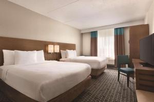 a hotel room with two beds and a television at Park Inn by Radisson Brampton, ON in Brampton