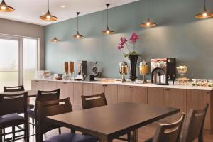 a restaurant with a table and chairs and a counter at Park Inn by Radisson Brampton, ON in Brampton