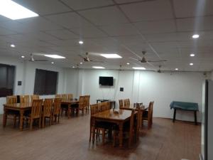 a dining room with tables and chairs and a tv at Hotel prayagraj in Barkot +19 photos