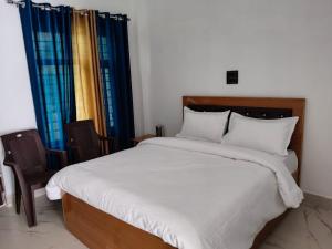 a bedroom with a large bed and two chairs at Hotel prayagraj in Barkot